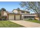 Charming two-story home with a long driveway, a two-car garage, and a sunroom at 10223 W 77Th Dr, Arvada, CO 80005