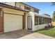 Home exterior featuring a garage, walkway, and enclosed sunroom, providing extra living space at 10223 W 77Th Dr, Arvada, CO 80005