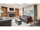Cozy living room with a brick fireplace, built-in bookshelves, and comfortable seating at 10223 W 77Th Dr, Arvada, CO 80005