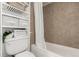 Compact bathroom with a shower-tub combination, tiled walls, and smart storage solutions maximizes space at 9725 E Harvard Ave # 418, Denver, CO 80231