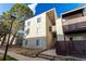Building exterior featuring balconies, updated siding, and mature trees around the property at 9725 E Harvard Ave # 418, Denver, CO 80231