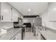 Galley style kitchen with stainless steel appliances, granite countertops, and white cabinets at 9725 E Harvard Ave # 418, Denver, CO 80231