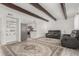 Open concept living room with a built-in shelving unit, beamed ceilings and sightlines to the kitchen at 9725 E Harvard Ave # 418, Denver, CO 80231