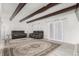 Living room with beamed ceilings, an oversized area rug and a sliding glass door to the outside at 9725 E Harvard Ave # 418, Denver, CO 80231