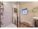 Well-lit bathroom featuring a modern shower, bright walls, and tile flooring at 3493 S Eudora St, Denver, CO 80222