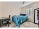This carpeted bedroom has a desk and chair, as well as a twin bed with blue covers and side table at 3493 S Eudora St, Denver, CO 80222