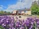 Charming home featuring solar panels, complemented by vibrant purple flowers, and beautiful landscaping at 3493 S Eudora St, Denver, CO 80222