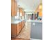 Bright kitchen featuring a full suite of appliances, tile flooring, natural wood cabinets and large windows at 3493 S Eudora St, Denver, CO 80222
