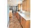 Spacious kitchen with modern appliances, tile flooring, natural wood cabinets, and plenty of counter space at 3493 S Eudora St, Denver, CO 80222