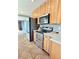 Functional kitchen with stainless steel appliances, natural wood cabinets, and tile flooring at 3493 S Eudora St, Denver, CO 80222
