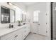 Bright bathroom with double vanity, modern fixtures, and black-framed mirrors, offering a clean and contemporary space at 16722 Shoshone St, Broomfield, CO 80023