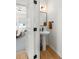 This bathroom features a pedestal sink with black fixtures, a black framed mirror, and wood look flooring at 16722 Shoshone St, Broomfield, CO 80023
