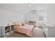 Bright bedroom features a pink bed, mini-split AC, desk, and custom storage for a cute, comfortable space at 16722 Shoshone St, Broomfield, CO 80023