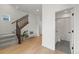 Bright foyer featuring hardwood floors, stairs, and stylish decor, leading to a half-bath and other rooms at 16722 Shoshone St, Broomfield, CO 80023