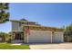 Charming home featuring a stone-accented, attached two-car garage and well-maintained lawn at 4276 S Tempe Ct, Aurora, CO 80018