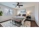 Cozy bedroom with a ceiling fan, large window, and a decorative bench at the foot of the bed at 4620 E 135Th Way, Thornton, CO 80241