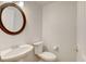 Clean and updated half bathroom with an oval mirror and pedestal sink at 9343 Amison Cir # 103, Parker, CO 80134