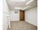 Clean basement area featuring a built-in bookcase, carpeted floors, and natural light from a window at 10375 E Weaver Cir, Englewood, CO 80111