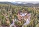 Aerial view of a home nestled in a lush, green forest with mountain views at 5254 Cheyenne Rd, Indian Hills, CO 80454