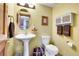 Stylish half bathroom with pedestal sink, decorative mirror, and storage, creating an inviting and functional space at 5254 Cheyenne Rd, Indian Hills, CO 80454