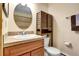 Bathroom featuring a stylish vanity, sink, toilet, and a mirror at 5254 Cheyenne Rd, Indian Hills, CO 80454