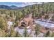 Charming home nestled in the mountains with a deck and beautiful natural landscaping and partial snow cover at 5254 Cheyenne Rd, Indian Hills, CO 80454