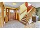 Inviting foyer with decorative tile floors, a wood front door, and staircase leading to the upper level at 5254 Cheyenne Rd, Indian Hills, CO 80454