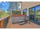 View of the deck with a hot tub and a grill, with a sliding glass door in the background at 5254 Cheyenne Rd, Indian Hills, CO 80454