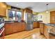 Well-lit kitchen with stainless steel appliances, wood cabinets, granite countertops, and hardwood floors at 5254 Cheyenne Rd, Indian Hills, CO 80454