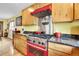 Well-equipped kitchen featuring a red range, stainless steel vent hood, and granite countertops at 5254 Cheyenne Rd, Indian Hills, CO 80454