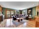 Cozy living room with a leather sectional, hardwood floors, and mountain views from the sliding door and windows at 5254 Cheyenne Rd, Indian Hills, CO 80454