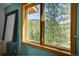 A nice wooden window frame overlooking the forest at 5254 Cheyenne Rd, Indian Hills, CO 80454