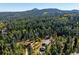 Scenic aerial view of a home nestled among lush green trees with a mountain in the background at 28553 Birch Ln, Conifer, CO 80433