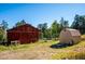 Rustic red barn and outbuilding add charm, with clear skies and natural surroundings at 28553 Birch Ln, Conifer, CO 80433