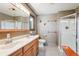 Well-lit bathroom with double sinks, shower, and rustic decor accents at 28553 Birch Ln, Conifer, CO 80433