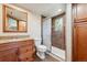 Bathroom features granite countertop, decorative mirror, tiled shower with glass door, and window at 28553 Birch Ln, Conifer, CO 80433