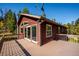 Angle view of the deck showing a wood house, large windows and a satellite dish in the forest at 28553 Birch Ln, Conifer, CO 80433