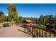 Deck view overlooking treed landscape, outbuildings, and fenced yard offering tranquility and natural beauty at 28553 Birch Ln, Conifer, CO 80433