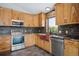 Kitchen features wooden cabinets, stainless steel appliances, granite countertops, and a copper sink at 28553 Birch Ln, Conifer, CO 80433