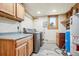 Functional laundry room equipped with washer, dryer, utility sink, storage, and natural light at 28553 Birch Ln, Conifer, CO 80433