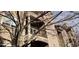 Exterior view of a multi-story apartment building with balconies seen through tree branches at 7355 S Alkire St # 203, Littleton, CO 80127