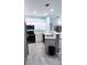 Open-concept kitchen with white cabinets, black appliances, an eat-up breakfast bar, and wood-look laminate flooring at 7355 S Alkire St # 203, Littleton, CO 80127