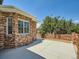 A backyard features a concrete patio with brick walls and shade trees in a pleasant outdoor space at 3810 Urban St, Wheat Ridge, CO 80033