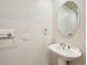 Stylish pedestal sink and oval mirror against light walls in a half bathroom at 3810 Urban St, Wheat Ridge, CO 80033