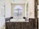 Elegant bathroom featuring a soaking tub with an arched window and custom marble tile at 3810 Urban St, Wheat Ridge, CO 80033
