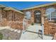 Close up of entryway featuring brickwork, arched windows, a decorative door, and an iron gate at 3810 Urban St, Wheat Ridge, CO 80033
