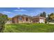 Charming brick home featuring lush lawn, attached garage, manicured landscaping, and mature trees on a sunny day at 3810 Urban St, Wheat Ridge, CO 80033