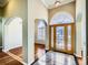 A naturally lit foyer featuring high ceilings, marble floors, and an arched entrance with wood floors beyond at 3810 Urban St, Wheat Ridge, CO 80033