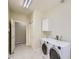 Bright laundry room with tile flooring, sink, cabinets, and modern washer and dryer at 3810 Urban St, Wheat Ridge, CO 80033