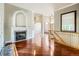 Open living room with hardwood floors, arched fireplace, and staircase with wood railing at 3810 Urban St, Wheat Ridge, CO 80033